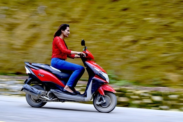 Chica conduciendo scooter eficiente por Ibiza